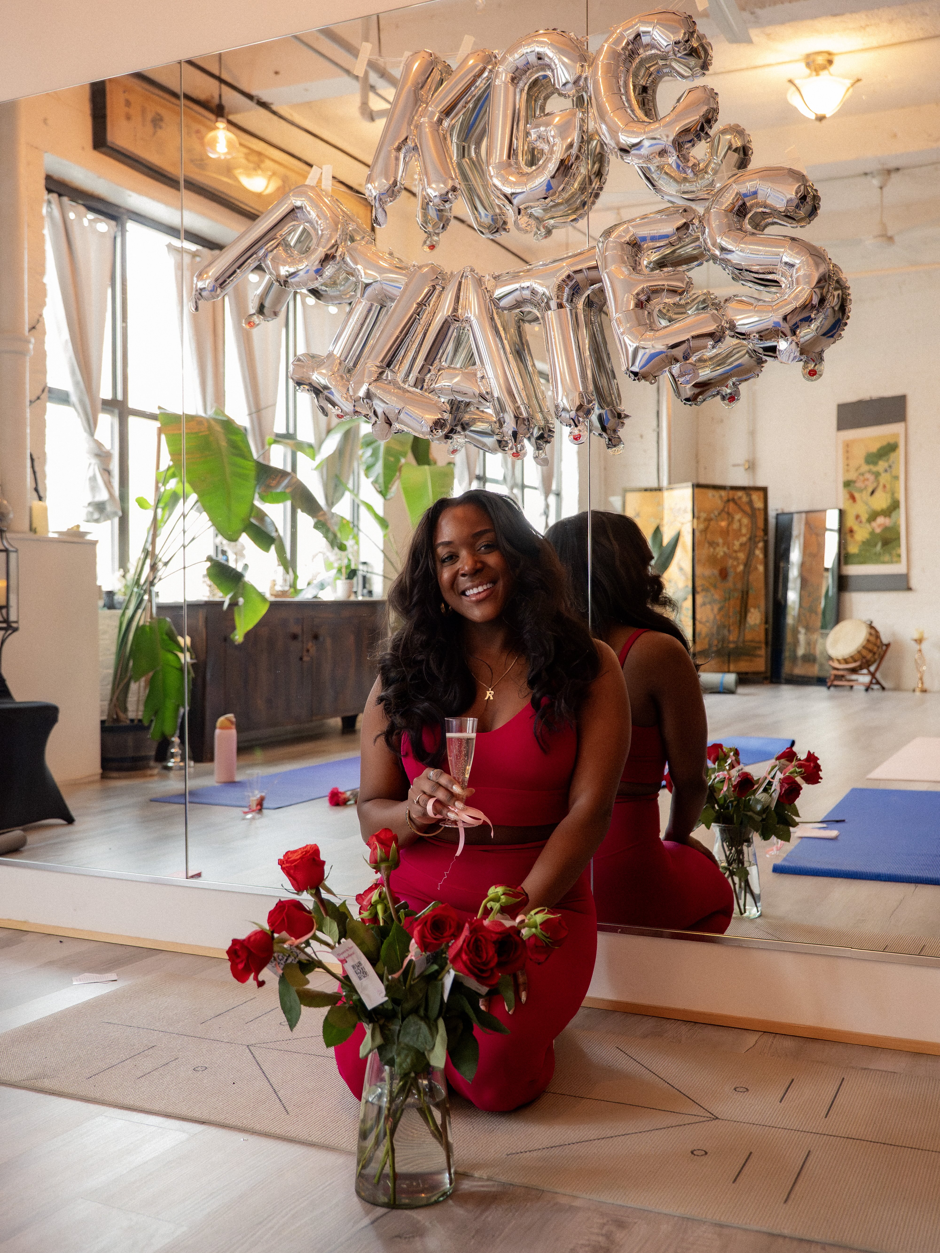 Kiersten celebrating with champagne and roses at KGC Pilates